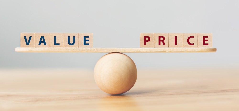 Wooden seesaw scale empty on wooden sphere on wood table with wording VALUE and PRICE balancing