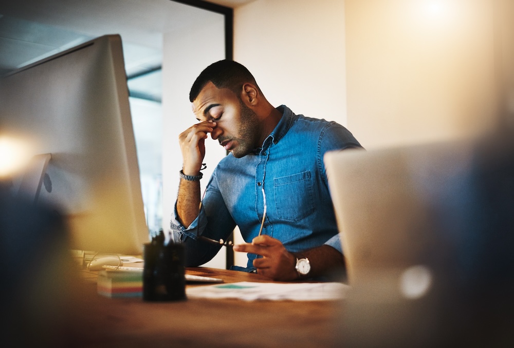 Office worker experiencing fatigue and difficulty concentrating, illustrating how hydration supports workplace focus and performance.